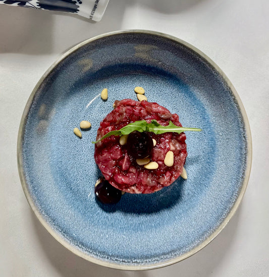 Tartare di scamone di manzo con amarene Fabbri su piatto bianco, ricetta gourmet di Chef Oscar per Essenza Pisterzi