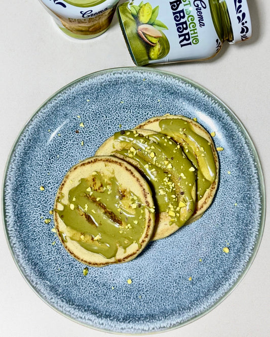 cakes soffici all’albume con crema al pistacchio e granella, su piatto bianco – ricetta fit e gourmet di Chef Oscar Pisterzi.